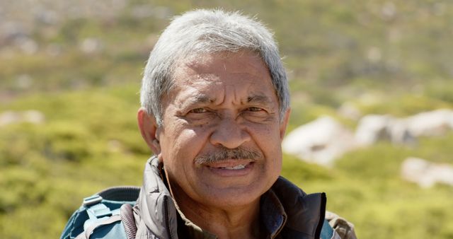 Elderly man enjoying a sunny day outdoors, perfect for themes related to active aging, retirement, outdoor activities, enjoying nature, health and wellness, or travel and exploration.