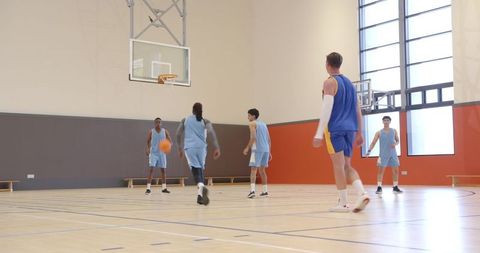 Energetic Basketball Team Practice in Bright Indoor Court