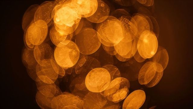 Glowing amber bokeh orbs creating abstract warm light pattern for background