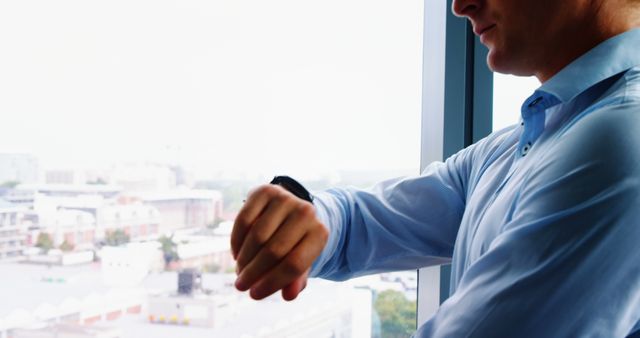 Businessman Checking Time on Smartwatch by Office Window - Download Free Stock Images Pikwizard.com