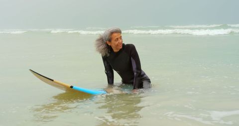 Senior Surfer Enjoying Ocean Waves with Surfboard at Sea