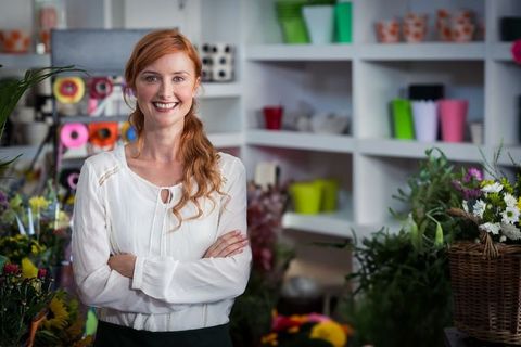 Confident Florist Standing in Her Lush Flower Shop