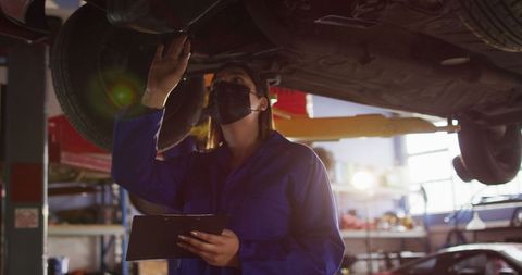 Female Mechanic in Mask Inspects Car at Service Station - Download Free Stock Images Pikwizard.com