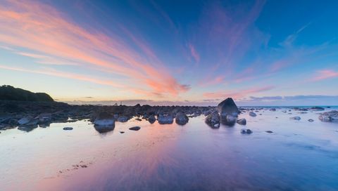 Sunset Sky Glowing Over Rocky Tidal Pools Reflecting Pastel Pink and Blue Hues