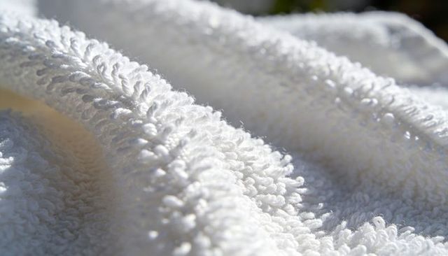 White terry cloth close-up showing looped pile and folded ridges texture