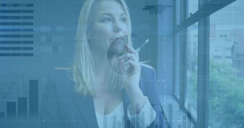 Contemplative businesswoman analyzing financial charts through office window with pen