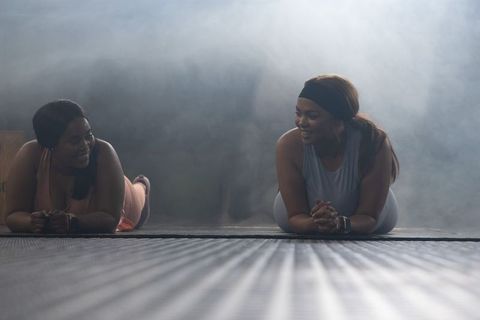 Holding forearm plank together african american women smiling during partner workout