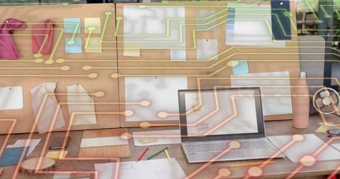 Creative workspace with laptop and corkboard blending circuit overlay for design and tech planning