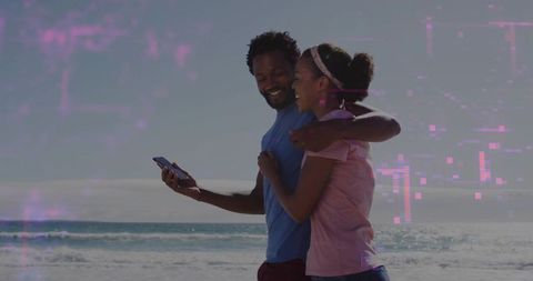 Couple embracing on beach sharing phone moments with magenta glitch overlay at horizon