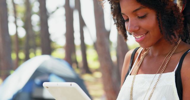 Smiling African-American Woman Using Tablet at Campsite - Download Free Stock Images Pikwizard.com