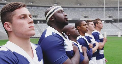 Rugby team standing for national anthem in stadium