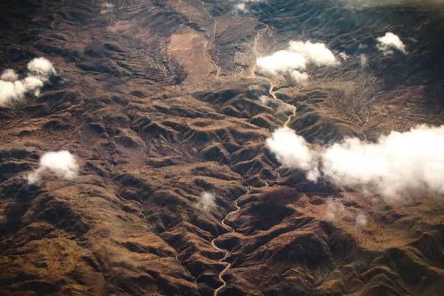 Aerial View of Rugged Mountain Terrain with Clouds - Download Free Stock Photos Pikwizard.com