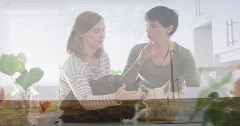 Double exposure domestic scene with two women holding small dog and wind turbines daylight