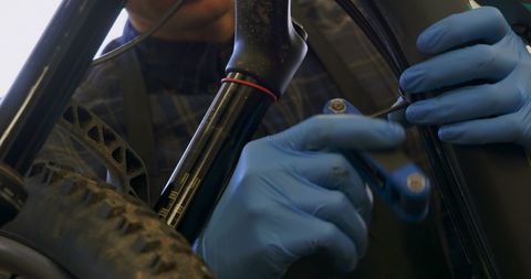 Close-Up of Technician's Hands Performing Bicycle Repair with Precision