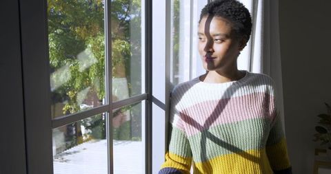 Woman Relaxing by Sunlit Window in Cozy Home