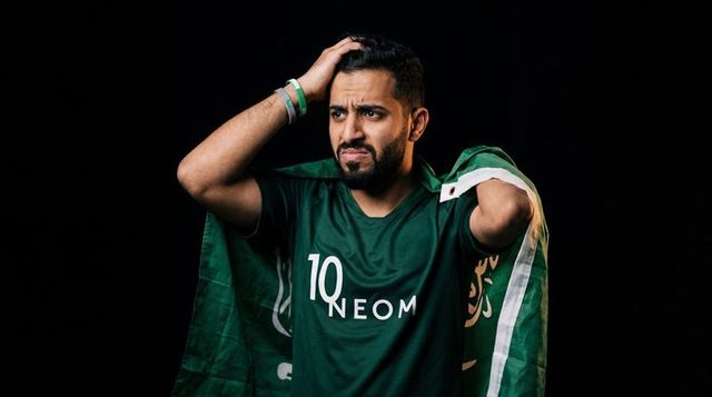 Disappointed saudi football fan clutching head wearing neom jersey 10 with flag