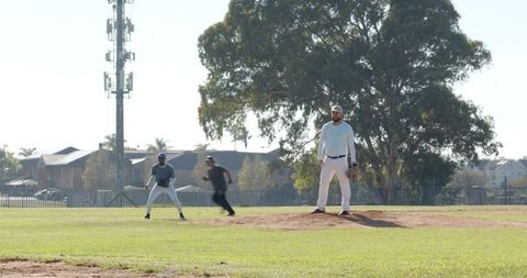 Pitching on Mound in Sunlit Neighborhood Park Holding Glove with Open Copy Space and Grass