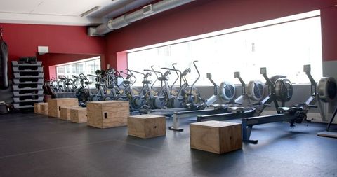 Modern gym with stationary bikes and rowing machines