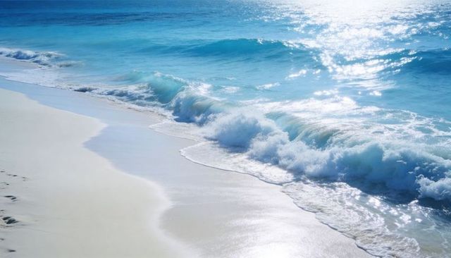 Turquoise waves rolling onto pristine white sand with sunlit foam and lonely footprints