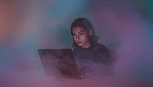 Focused Woman Using Laptop with Mystical Cosmic Background