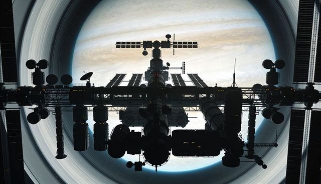 Silhouette Space Station Above Ringed Gas Giant with Truss Backbone and Solar Arrays