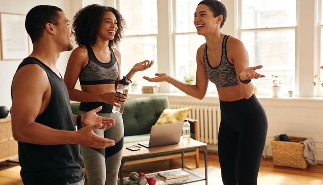 Sharing home workout laughs: group training in sunlit apartment living room