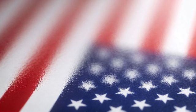 Glossy american flag close-up reflecting studio light, stars and stripes macro