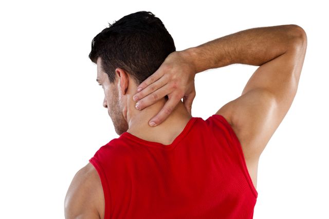 Rear view of American football player suffering from neck pain while standing against white background