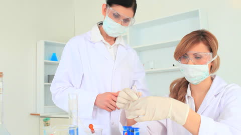 Scientists Conducting Experiment Using Test Tubes in Laboratory