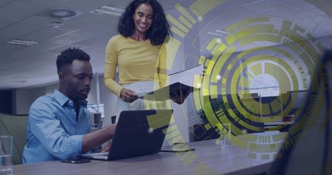 Overseeing colleague working on laptop with futuristic HUD overlay for tech collaboration