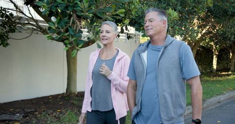 Senior couple strolling in nature checking smartwatch