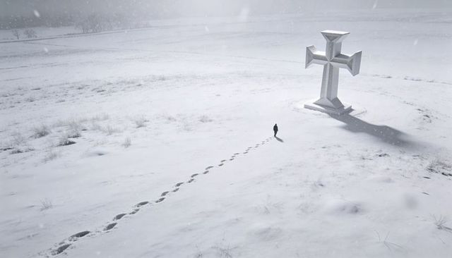 Solitary walker approaching oversized stone cross on snowy plain leaving deep footprints