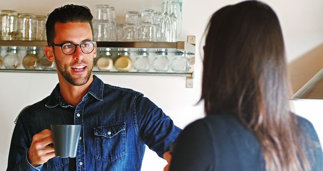 Man with Glasses Holding Coffee Mug Talking to Friend in Kitchen - Download Free Stock Images Pikwizard.com