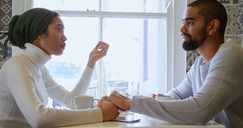 Couple engaged in intimate conversation over coffee in bright ambiance