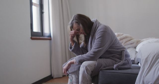 Elderly Woman Sitting on Bed, Looking Distressed - Download Free Stock Images Pikwizard.com