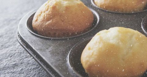 Freshly baked golden brown muffins in metal tin
