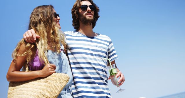 Young Couple Relaxing on Sunny Beach with Drinks - Download Free Stock Images Pikwizard.com