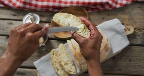 Hand Spreading Butter on Fresh Bread Slice in Rustic Kitchen - Download Free Stock Images Pikwizard.com