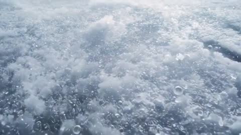 Macro slow-motion of air bubbles rising and bursting in thawing pond ice surface