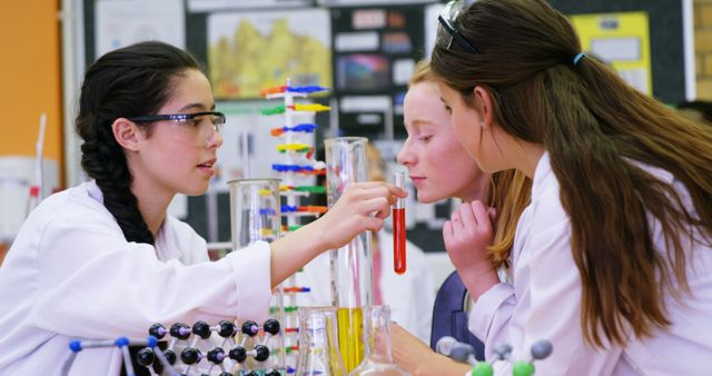 Two young Caucasian girls are engaged in a scientific experiment in a laboratory setting, with copy space. Dressed in white lab coats, they are focused on analyzing test tubes, showcasing a learning environment that encourages hands-on experience in science.