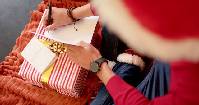 Person Writing Holiday Card Near Christmas Gift - Download Free Stock Images Pikwizard.com