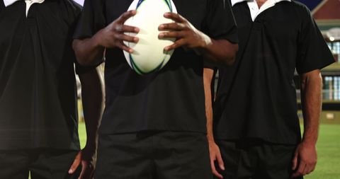 Diverse rugby players holding ball at stadium