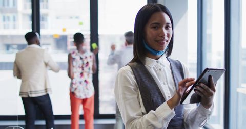 Smiling Asian Businesswoman Using Tablet with Mask at Office