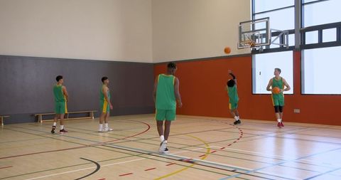 Male Basketball Team Practicing in Indoor Gymnasium