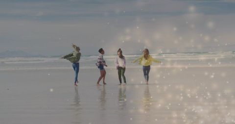 Friends Dancing on Beach with Sparkling Ocean Background