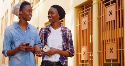 Joyful twin sisters strolling in urban setting