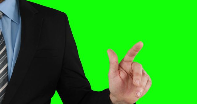 A middle-aged Caucasian businessman in a suit gestures with his hand against a green screen background, with copy space. His hand position suggests he's interacting with a virtual interface or giving a presentation.