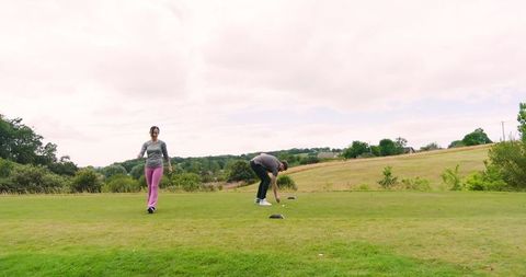 Couple preparing for round of golf on tee box