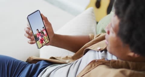 Man Watching Soccer Video on Smartphone at Home