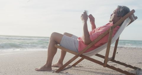Senior Man Relaxing on Beach Using Smartphone at Sunset - Download Free Stock Images Pikwizard.com